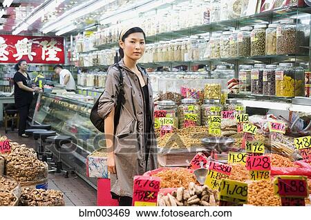 Stock Photo - Asian woman shopping in grocery store. Fotosearch