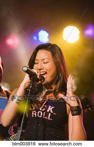 Asian woman singing onstage View Large Photo Image Stock Photograph - Asian woman singing onstage. Fotosearch
