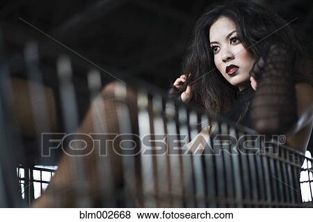 Stock Photo - Asian woman sitting in shopping cart. Fotosearch