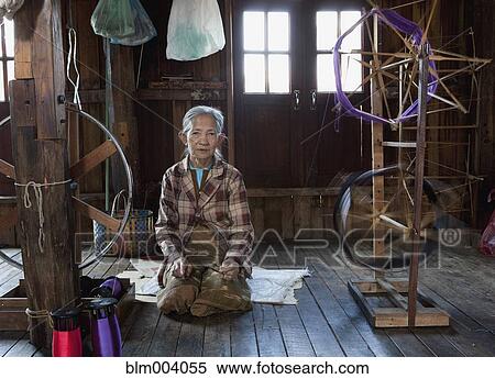 Stock Photography - Asian woman sitting near loom. Fotosearch