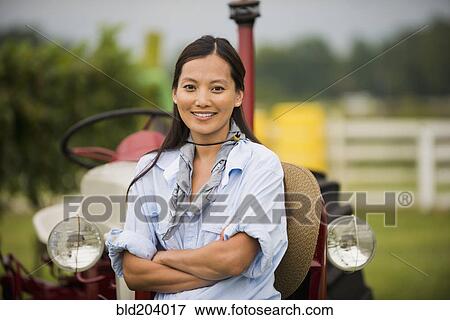 Stock Photo - Asian woman smiling in field. Fotosearch