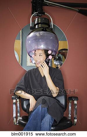 Stock Photography - Asian woman under hair dryer in salon. Fotosearch