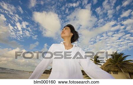 Asian woman walking under blue sky with clouds View Large Photo Image Stock Image - Asian woman walking under blue sky with clouds. Fotosearch