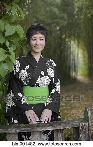 Stock Image - Asian woman wearing traditional robe in forest. Fotosearch