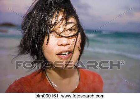 Asian woman with hair blowing at beach View Large Photo Image Stock Image - Asian woman with hair blowing at beach. Fotosearch
