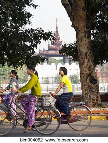 Asian women bicycling with temple in background View Large Photo Image Stock Image - Asian women bicycling with temple in background. Fotosearch