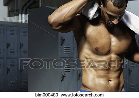 Stock Image - Bare chested mixed race man in locker room. Fotosearch