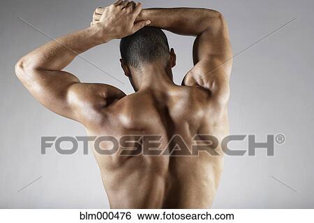 Stock Photograph - Bare chested mixed race man with arms raised. Fotosearch