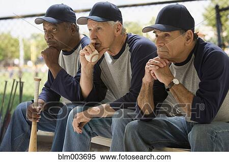 Baseball players looking serious on bench View Large Photo Image Stock Photography - Baseball players looking serious on bench. Fotosearch
