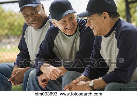 Stock Image - Baseball players talking on bench. Fotosearch