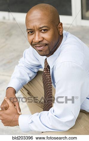 Black businessman sitting outdoors View Large Photo Image Stock Photograph - Black businessman sitting outdoors. Fotosearch