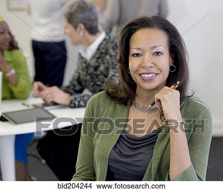 Black businesswoman smiling in office View Large Photo Image Picture - Black businesswoman smiling in office. Fotosearch