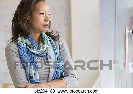 Black businesswoman standing in office View Large Photo Image Stock Photo - Black businesswoman standing in office. Fotosearch