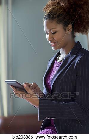 Stock Photography - Black businesswoman using tablet computer. Fotosearch