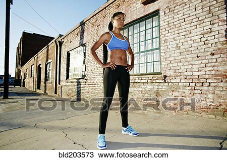 Stock Image - Black runner standing on city street. Fotosearch