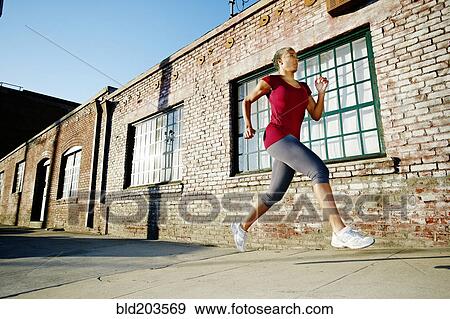 Stock Photo - Black woman running on city street. Fotosearch