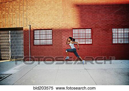 Stock Photography - Black woman running on city street. Fotosearch