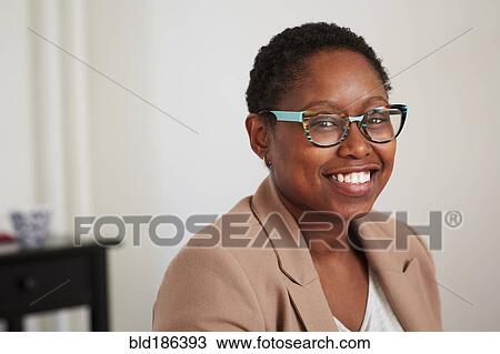 Stock Image - Black woman smiling indoors. Fotosearch