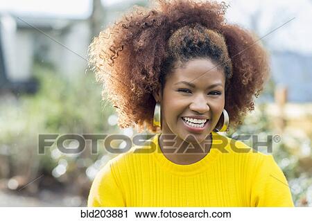 Stock Image - Black woman smiling outdoors. Fotosearch