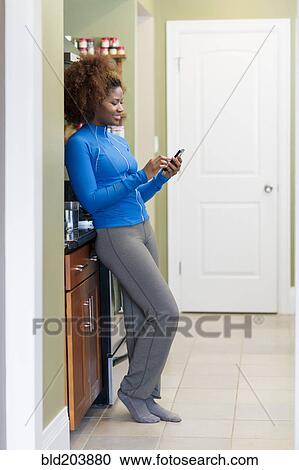 Stock Image - Black woman using cell phone. Fotosearch