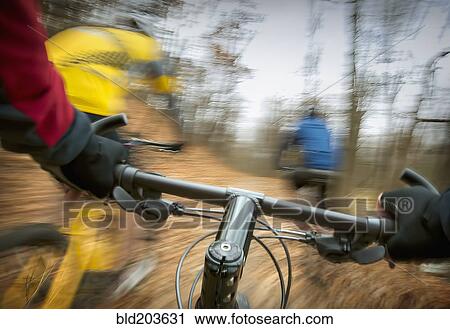 Stock Image - Blurred view of mountain bike in forest. Fotosearch
