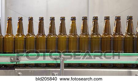 Stock Image - Bottles on production line in bottling plant. Fotosearch