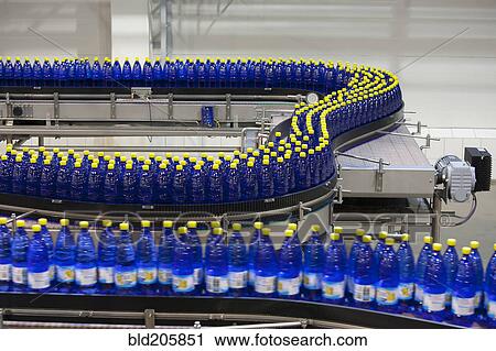 Stock Image - Bottles on production line in bottling plant. Fotosearch