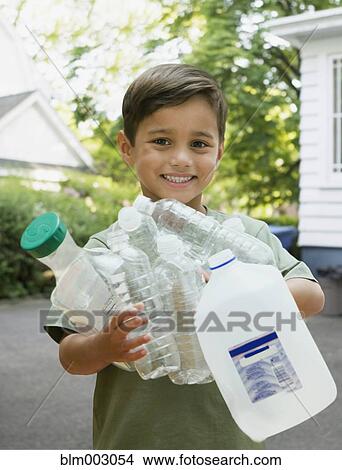Picture - Boy carrying empty recyclable bottles. Fotosearch