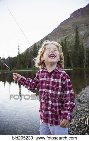 Boy making a face by still rural lake View Large Photo Image Stock Photo - Boy making a face by still rural lake. Fotosearch