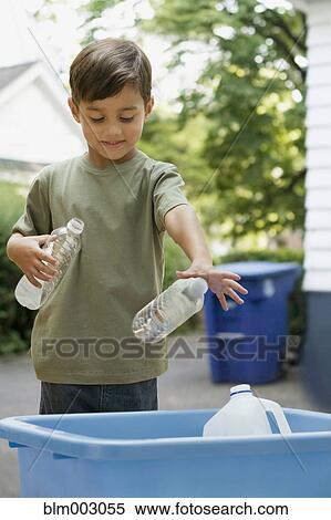 Stock Photography - Boy tossing recyclable bottles into bin. Fotosearch