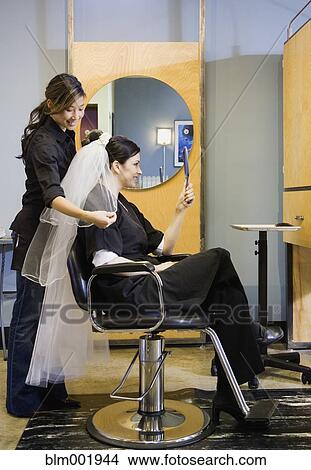 Bride looking at hair and veil at salon View Large Photo Image Picture - Bride looking at hair and veil at salon. Fotosearch