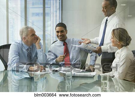 Business people discussing document in meeting View Large Photo Image Picture - Business people discussing document in meeting. Fotosearch