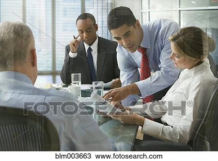 Stock Image - Business people discussing document in meeting. Fotosearch