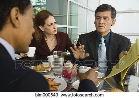 Stock Photo - Business people having meeting in restaurant. Fotosearch