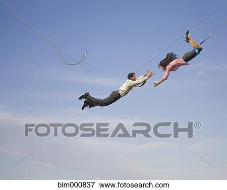 Stock Photo - Business people on flying trapeze. Fotosearch