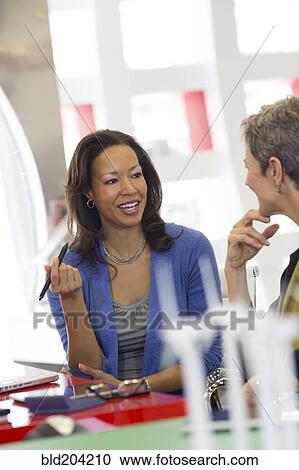 Stock Image - Business people talking in meeting. Fotosearch