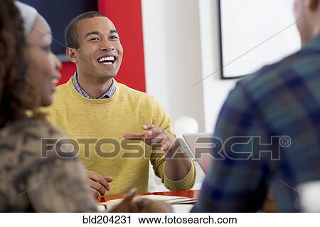 Stock Image - Business people talking in meeting. Fotosearch