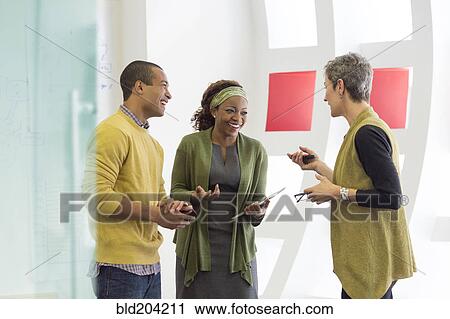 Stock Image - Business people talking in office. Fotosearch
