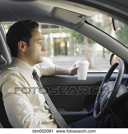 Stock Image - Businessman driving and drinking coffee. Fotosearch