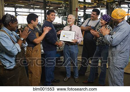 Businessman giving award to warehouse worker View Large Photo Image Stock Image - Businessman giving award to warehouse worker. Fotosearch