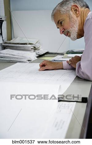 Stock Photo - Businessman looking at blueprints. Fotosearch