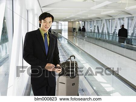 Businessman on moving walkway in airport View Large Photo Image Stock Image - Businessman on moving walkway in airport. Fotosearch