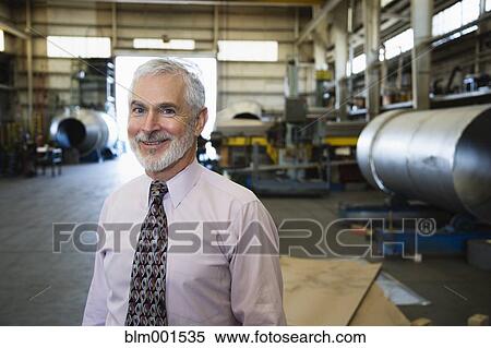 Stock Photography - Businessman smiling in warehouse. Fotosearch
