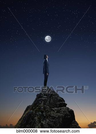 Stock Photo - Businessman standing on mountain top. Fotosearch