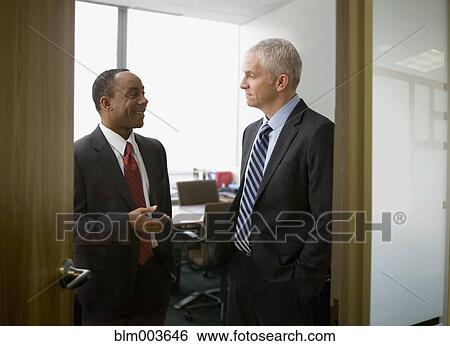Businessman talking in office View Large Photo Image Stock Photograph - Businessman talking in office. Fotosearch