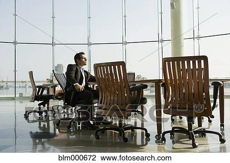 Stock Image - Businessman waiting in conference room for meeting. Fotosearch