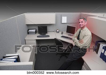 Stock Image - Businessman with horns in office cubicle. Fotosearch