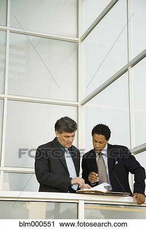 Businessmen having meeting on balcony View Large Photo Image Stock Image - Businessmen having meeting on balcony. Fotosearch