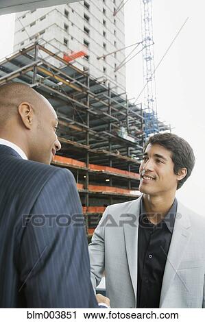 Stock Image - Businessmen standing face to face. Fotosearch