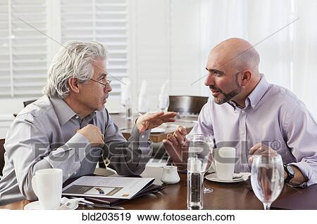 Stock Photo - Businessmen talking in cafe. Fotosearch